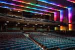 Interior del Ovens Auditorium con iluminación de colores y butacas azules