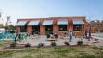 Vista exterior de NoDa Brewing Company con terraza y clientes disfrutando del ambiente