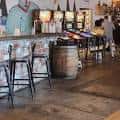 Interior del bar de Resident Culture Brewing Company con barriles y taburetes