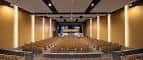 Interior del auditorio con butacas y escenario iluminado