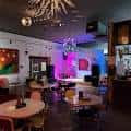 Interior del local con mesas, sillas y luces decorativas tipo estrella