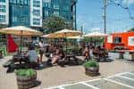 Terraza exterior de Birdsong Brewing Co. con clientes disfrutando en mesas y sombrillas