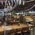 Interior del restaurante con mesas de madera y decoración industrial