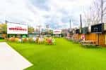 Área exterior con césped artificial y mesas para eventos