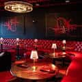 Sala de estar elegante con sofás rojos, lámparas de mesa y arte en las paredes