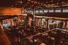 Vista interior del salón principal de Heist Brewery con iluminación cálida y ambiente festivo