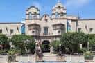 Fachada principal del museo en Balboa Park con banderas y jardines bien cuidados
