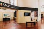 Interior de la sala de exposiciones 'RACE' con paneles informativos y mobiliario moderno