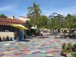 Plaza exterior con mesas bajo sombrillas y ambiente festivo para eventos