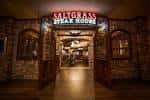 Entrada principal del Saltgrass Steak House con letrero iluminado y decoración rústica