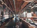 Interior del bar de Petty Thieves Brewing Co con barra larga y techos altos