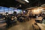 Interior del bar de Town Brewing Co con ambiente industrial y clientes disfrutando