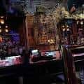 Vista interior del bar con iluminación cálida y detalles decorativos en el techo