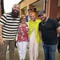 Grupo de personas sonriendo frente a la entrada del lugar