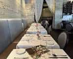 Interior del restaurante con mesas dispuestas para cena y decoración elegante