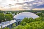 Vista aérea del Bojangles' Coliseum rodeado de árboles con el skyline de Charlotte al fondo