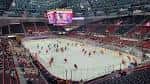 Partido de hockey en el interior del Bojangles' Coliseum con pista iluminada y graderías llenas