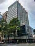 Edificio de oficinas moderno en Tryon Street con fachada de cristal y árboles urbanos