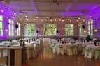 Interior del salón principal iluminado con luces púrpuras y decoración para celebración