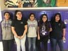 Estudiantes posando en un pasillo con murales artísticos