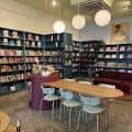 Interior acogedor de Kindred Stories con estanterías llenas de libros y zona de lectura