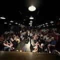 Interior del teatro con público sentado en filas frente al escenario