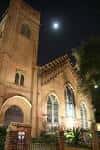 Vista nocturna de la fachada de la Catedral Christ Church con luna en el cielo