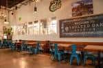 Interior del salón principal con mesas de madera y sillas azules