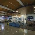 Interior del centro comunitario mostrando el área de recepción y sala de espera con mobiliario moderno
