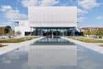 Vista exterior del Ismaili Center Houston con fachada moderna y reflejo en el agua