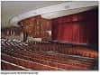 Interior del auditorio principal con butacas rojas y cortina de escenario