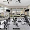 Gimnasio comunitario con equipamiento deportivo y grandes ventanales