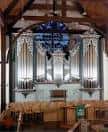 Órgano gótico con vitral azul en el interior de la iglesia