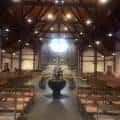 Interior de la iglesia con techo de vigas de madera y altar central