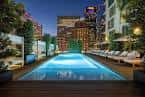 Piscina en la azotea del hotel con vistas a la ciudad al atardecer