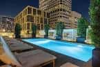 Área de piscina con tumbonas y ambiente nocturno relajante