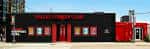 Vista exterior del Dallas Comedy Club con fachada negra y detalles en rojo