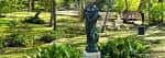 Escultura de bronce en medio del paisaje verde del jardín