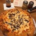 Pizza con champiñones sobre mesa de madera