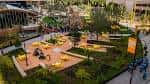 Plaza al aire libre con áreas verdes, asientos y espacios para eventos culturales