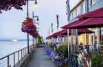 Terraza al aire libre del restaurante con macetas colgantes y vistas al agua en Seattle