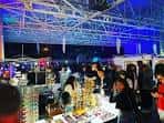 Evento nocturno en el Hangar 30 con iluminación azul y público asistiendo