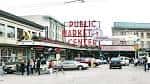 Entrada del Public Market Center con personas caminando y vehículos estacionados