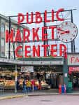 Primer plano del icónico letrero rojo 'Public Market Center' con reloj