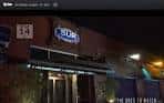 Fachada nocturna del Club Sur con letrero iluminado