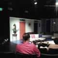 Interior del teatro mostrando escena en vivo con público sentado