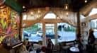 Vista del interior de Caffvino con decoración artística y ventanas luminosas