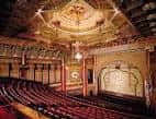 Interior del auditorio del 5th Avenue Theatre con techo ornamentado y butacas rojas