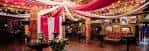 Salón de eventos decorado con telas rojas y doradas para celebraciones privadas