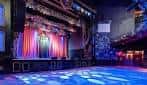 Escenario principal del House of Blues Dallas con cortinas rojas y piso de baile iluminado